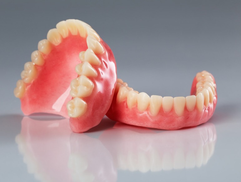 Complete upper denture shown from the side with visible denture teeth and base